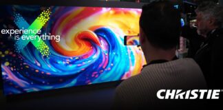 Pantalla LED de Christie en IAAPA Expo 2025 mostrando contenido visual inmersivo mientras los asistentes observan la demostración.