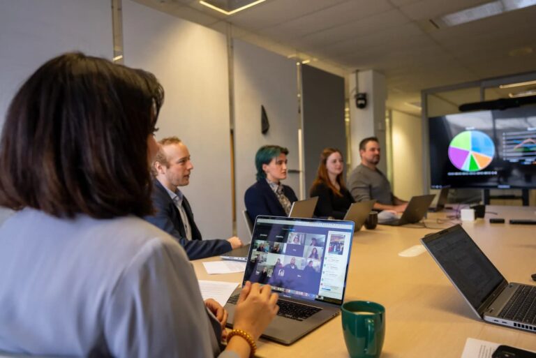 Quorum de Ross Video en una reunión híbrida corporativa con participantes presenciales y remotos en videollamada