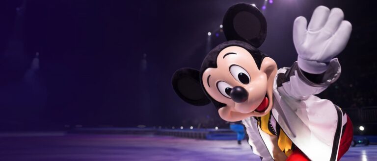 Mickey Mouse saluda al público en una función de BlackTrax en Disney on Ice sobre pista de hielo