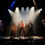 Meyer Sound en Los Miserables durante una escena coral en el Teatro Nuevo Apolo, con el elenco sobre el escenario bajo una iluminación dramática.