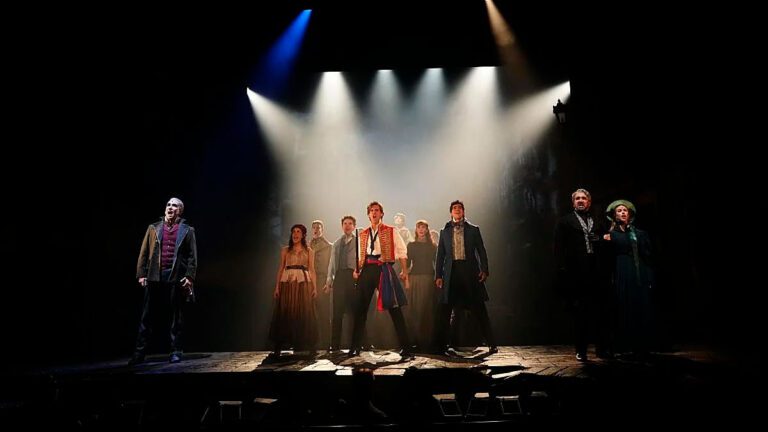 Meyer Sound en Los Miserables durante una escena coral en el Teatro Nuevo Apolo, con el elenco sobre el escenario bajo una iluminación dramática.