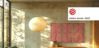 Panel acústico VicShape 3D de Vicoustic en color rosa instalado en una sala de estar moderna con mobiliario de madera y luz natural, ganador del Red Dot Product Design Award 2025.