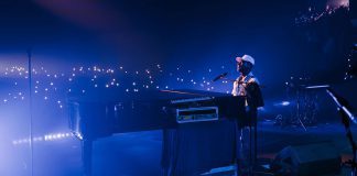 Jon Batiste durante su emotiva actuación en el Montreux Jazz Festival Miami 2025, acompañado por un mar de luces del público y sonido impecable proporcionado por Meyer Sound.