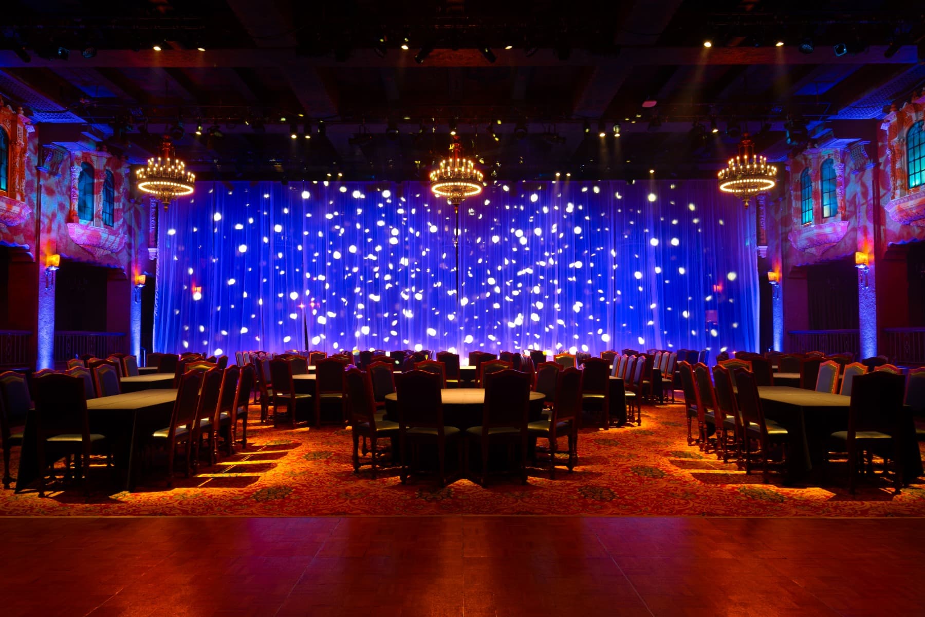 Vista del Marriner Theatre Plaza Ballroom iluminado con dispositivos Infinity y Showtec de Clearlight Shows, creando un ambiente espectacular para obras de teatro y eventos en vivo.