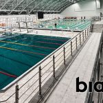 Piscina olímpica del Complejo Deportivo de Kazajistán equipada con sistemas de audio Biamp, garantizando sonido claro y resistente a la humedad para entrenamientos y competiciones.