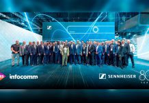 Equipo de Sennheiser en InfoComm 2025 frente al stand con tecnología TeamConnect Bar Solutions, celebrando su 80 aniversario en Orlando.
