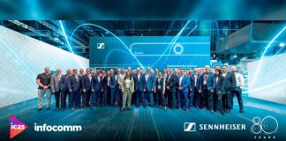 Equipo de Sennheiser en InfoComm 2025 frente al stand con tecnología TeamConnect Bar Solutions, celebrando su 80 aniversario en Orlando.