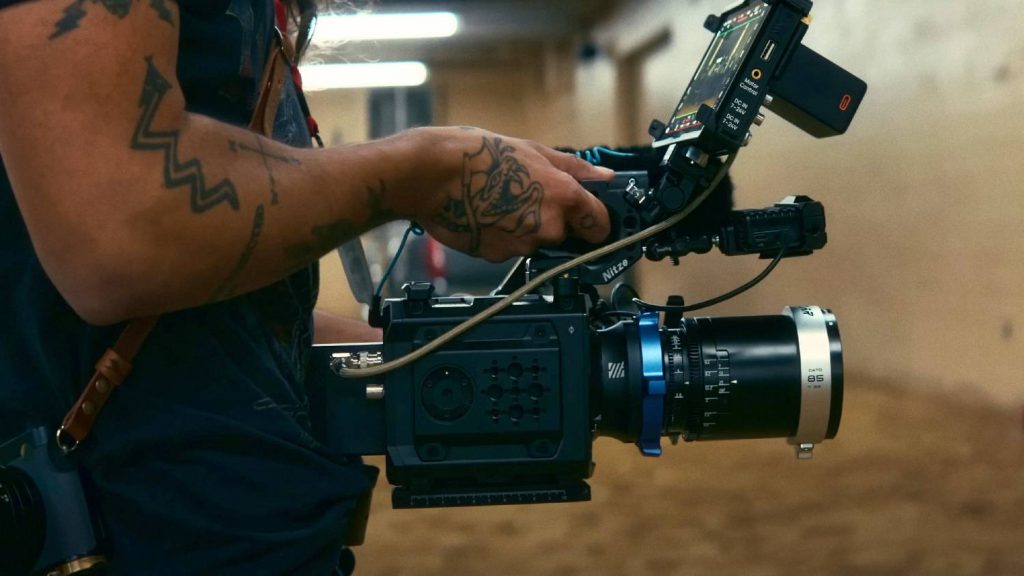 Cineasta operando una cámara cinematográfica digital Blackmagic PYXIS 6K con lente anamórfico en plena grabación del cortometraje documental sobre el rodeo indígena.