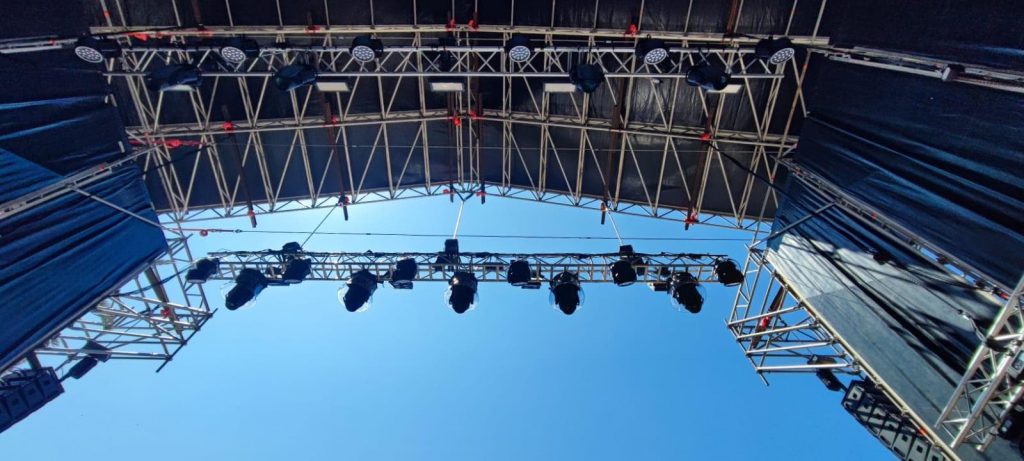 Estructura de iluminación frontal con focos Prolights y rigging técnico para el escenario principal del evento en Vallehermoso.