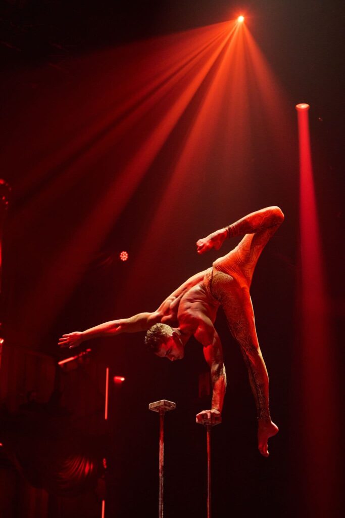Actuación de equilibrio acrobático bajo iluminación escénica roja proporcionada por cabezas móviles Robe en Circlassica.