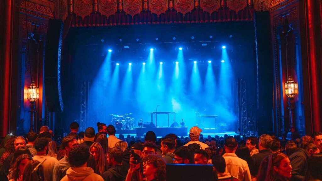 Público congregado en el Fox Theater durante un show en vivo con iluminación azul y sistema PANTHER visible
