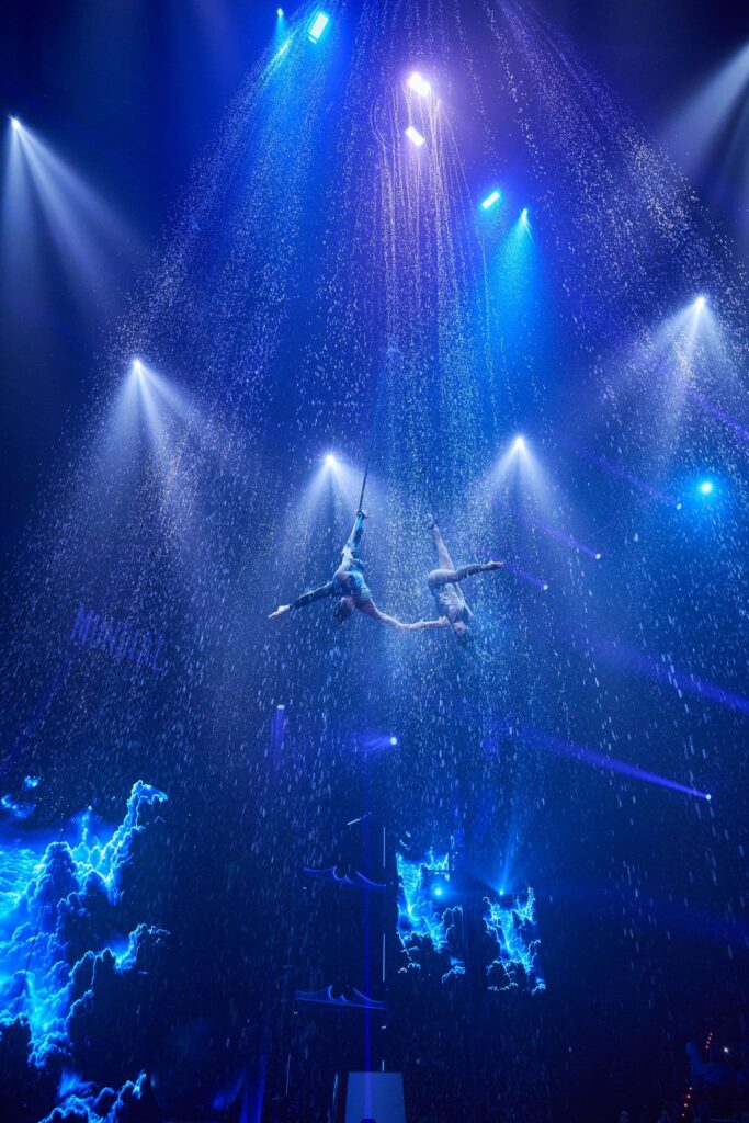 Número aéreo con efectos de lluvia y luces azuladas, resaltando el uso de cabezas móviles Robe en la escenografía de Circlassica.
