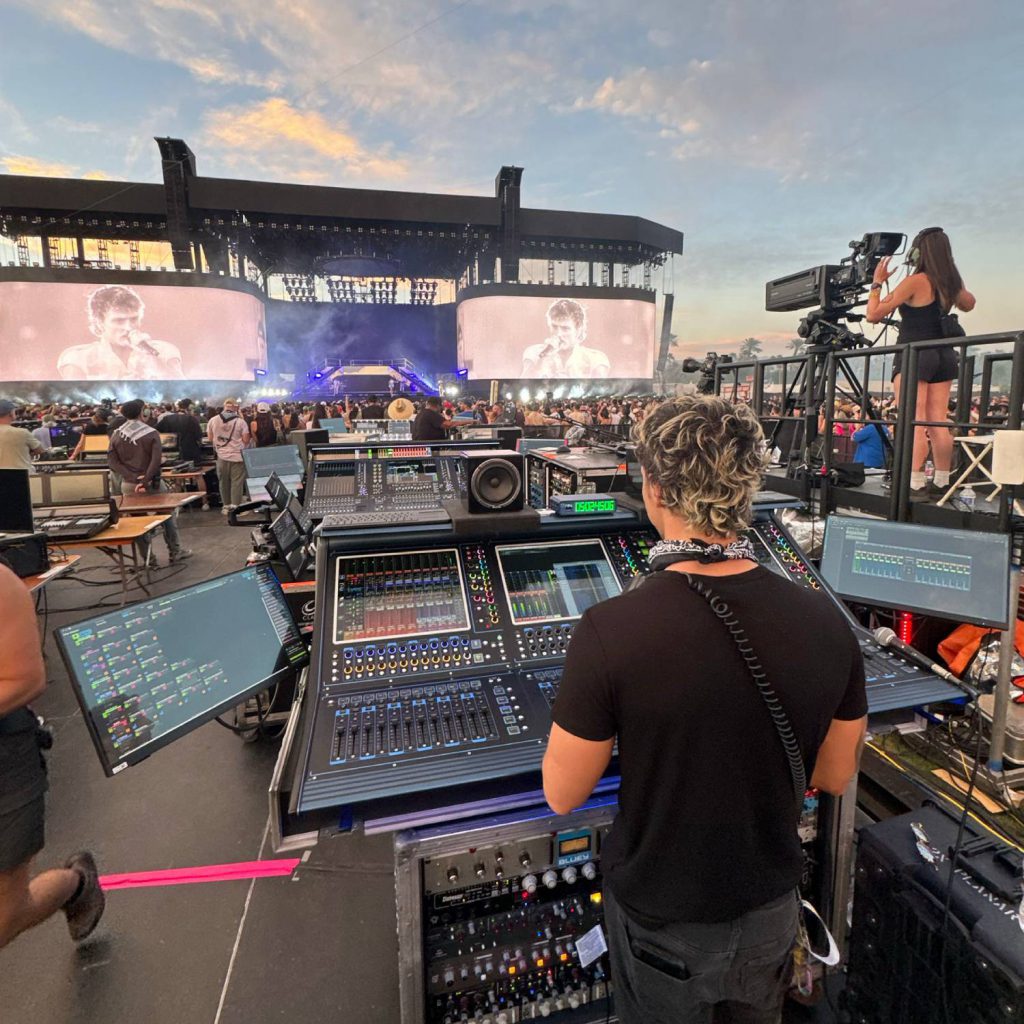 Vista desde la posición de FOH con la consola DiGiCo Quantum338 mientras Benson Boone actúa en un gran escenario al atardecer.