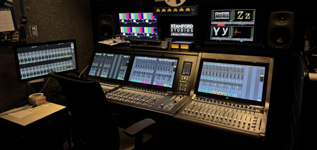 Consola System T instalada en la sala de control de NBCUniversal Stamford, mostrando su superficie S400 con pantallas táctiles activas y entorno de producción broadcast.