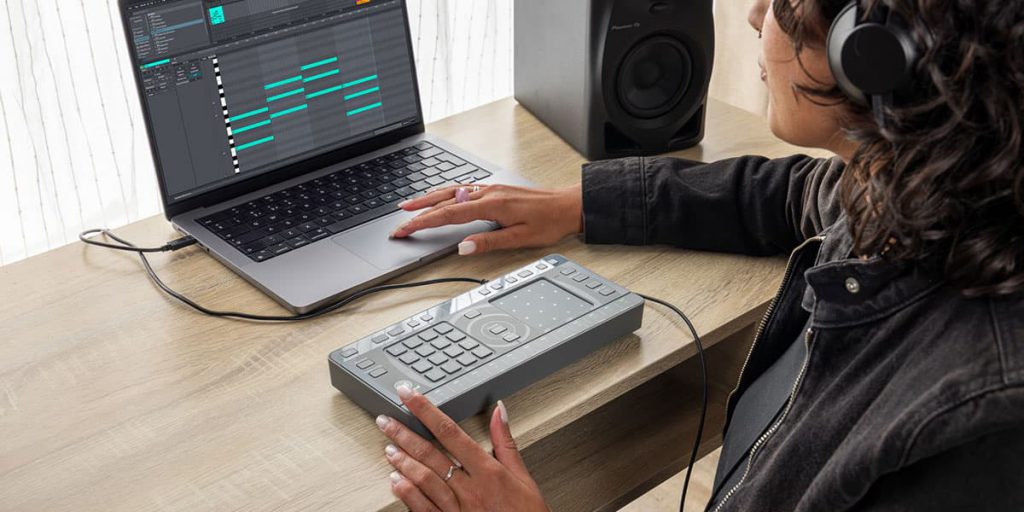 Productora musical conectando Chordcat a su DAW en portátil, componiendo progresiones de acordes en un entorno profesional.
