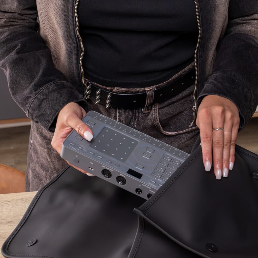 Groovebox Chordcat siendo guardado en una funda portátil, ideal para crear música en movimiento con total libertad.