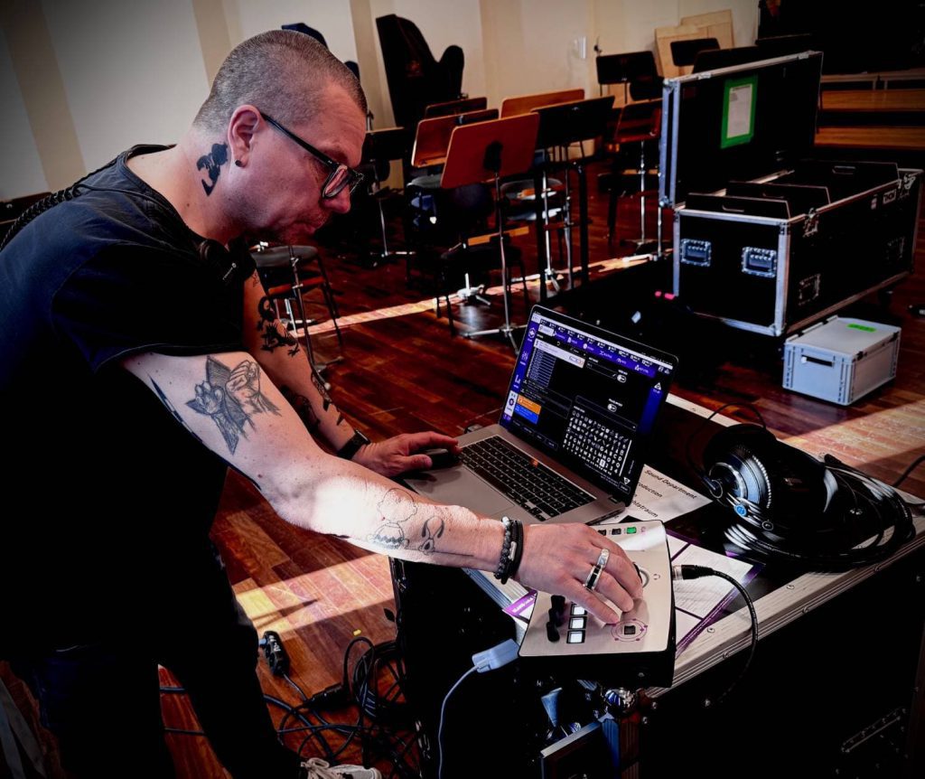 Interfaz de KLANG para músicos teatrales: mezcla inmersiva, control intuitivo y sonido profesional 3 Joerg Gruensfelder configurando la interfaz de KLANG desde su portátil y el controlador KLANG:kontroller, clave en la monitorización inmersiva de la producción teatral.