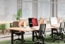 Oficina moderna equipada con tecnología de la actualización de Biamp Workplace, incluyendo panel Evoko Naso para reservas inteligentes y gestión eficiente de espacios.