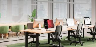 Oficina moderna equipada con tecnología de la actualización de Biamp Workplace, incluyendo panel Evoko Naso para reservas inteligentes y gestión eficiente de espacios.