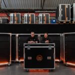 Chris Bogg y James Roberts, de dBS Solutions, junto a parte del nuevo inventario de recintos Wavefront Precision y el sistema WPL de Martin Audio.