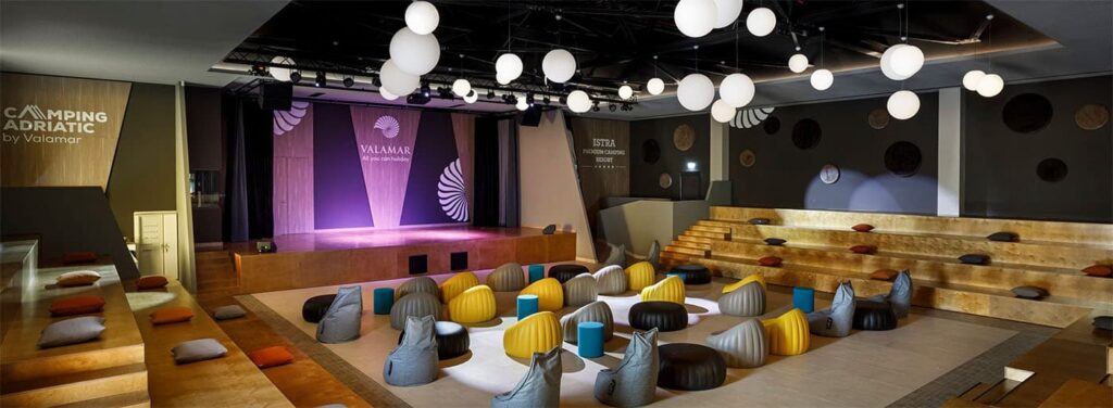 Interior del Istra Premium Camping Resort con sistema audiovisual Biamp, mostrando el escenario y la disposición de asientos en una de las más de 40 zonas controladas por Tesira.