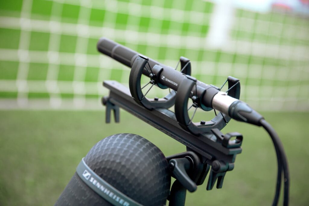 Micrófono de cañón estéreo Sennheiser MKH 8018 en uso en un estadio, diseñado para radiodifusión y cine profesional.