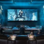 Estudio de postproducción profesional equipado con DaVinci Resolve de Blackmagic Design, donde un equipo de editores y coloristas trabaja en la corrección de color, edición y mezcla de audio de una película de ciencia ficción proyectada en una gran pantalla de cine.