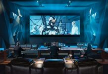 Estudio de postproducción profesional equipado con DaVinci Resolve de Blackmagic Design, donde un equipo de editores y coloristas trabaja en la corrección de color, edición y mezcla de audio de una película de ciencia ficción proyectada en una gran pantalla de cine.