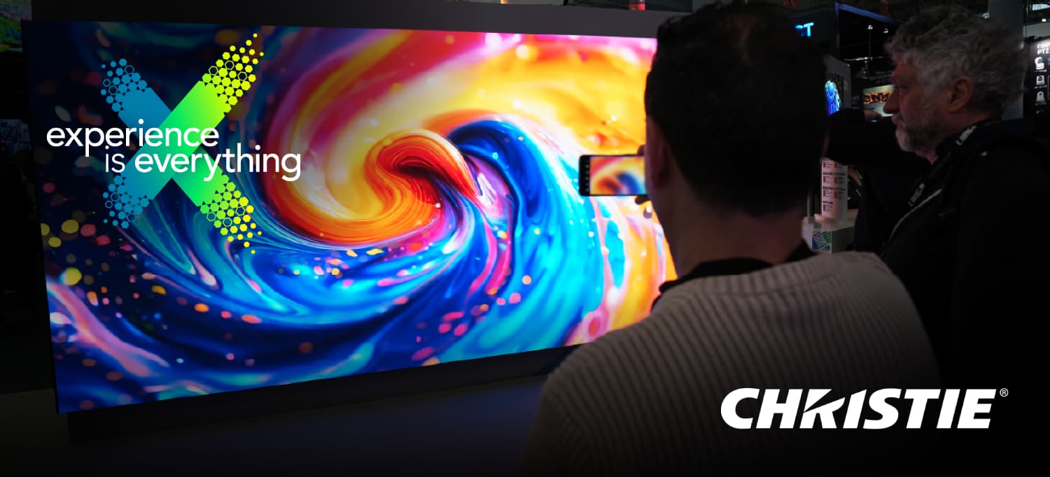 Pantalla LED de Christie en IAAPA Expo 2025 mostrando contenido visual inmersivo mientras los asistentes observan la demostración.
