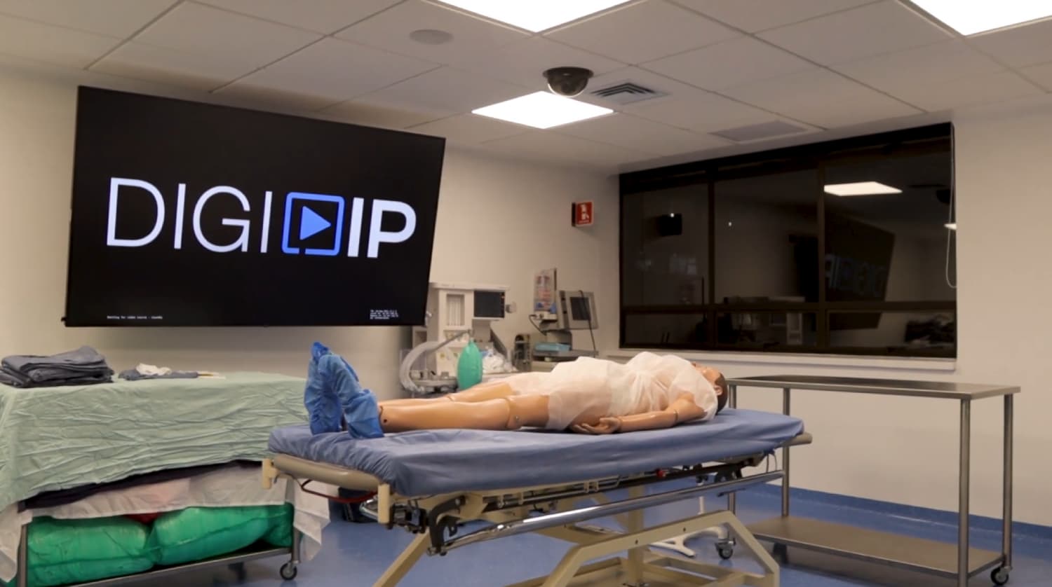 Sala de simulación médica de la Universidad Javeriana con maniquí de entrenamiento clínico y sistema audiovisual AREC utilizado para prácticas y grabación de procedimientos.