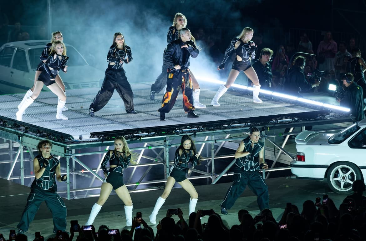 Donny Montell y su cuerpo de baile actuando sobre una plataforma iluminada con equipos Cameo, creando una estética cinematográfica en directo.