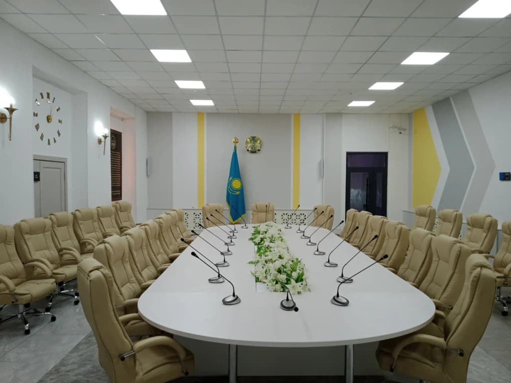 Sala de conferencias en la Facultad de Negocios y Arquitectura de Kazajistán equipada con micrófonos y mobiliario moderno