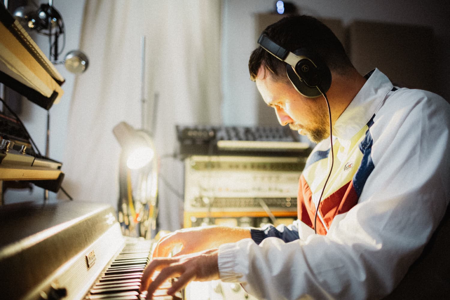 Músico trabajando en estudio con auriculares Austrian Audio Hi-X18 Gold edición limitada, ideal para mezcla y producción profesional.