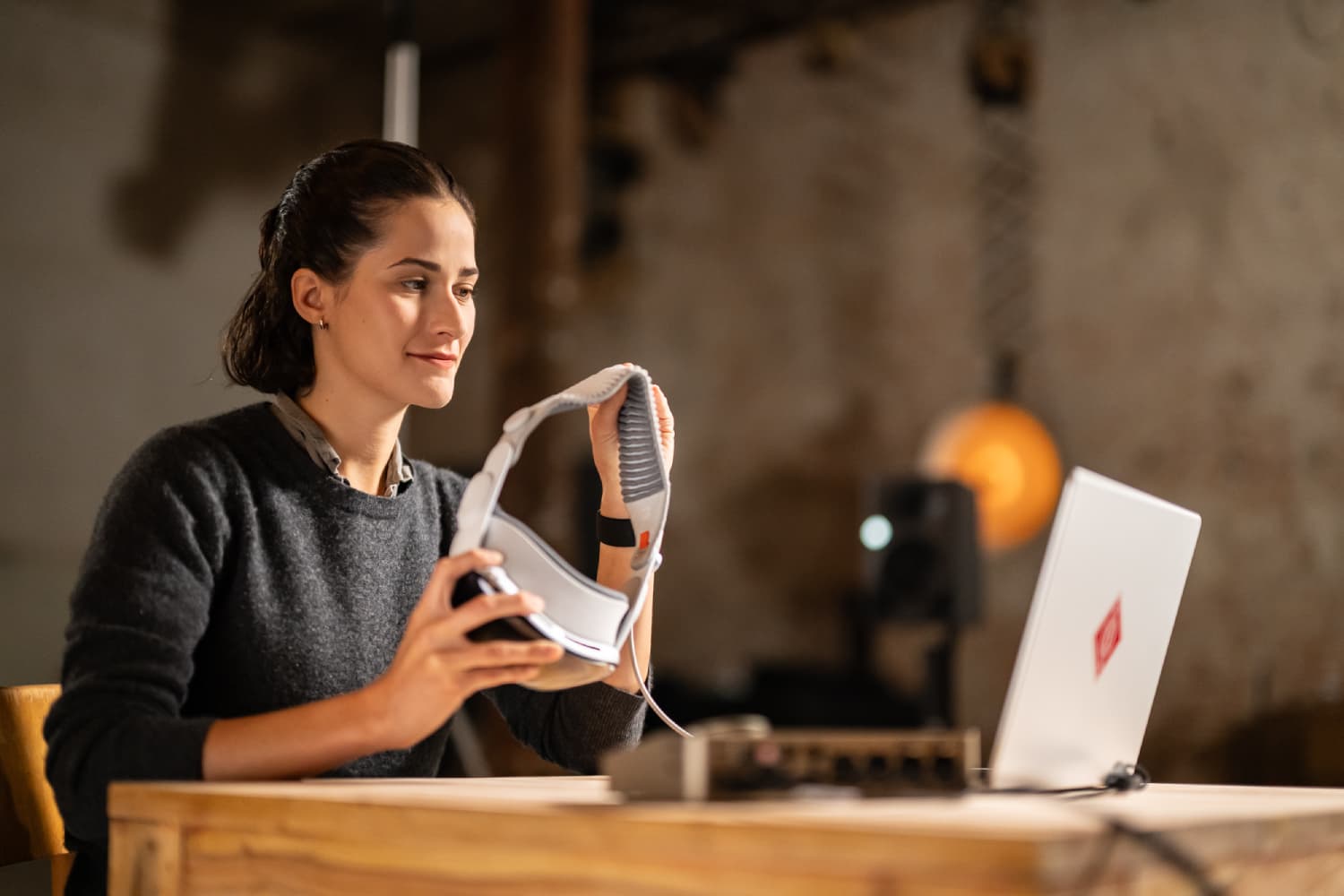 Profesional de audio utilizando Apple Vision Pro junto a un portátil mientras prepara una sesión con Neumann VIS mezcla inmersiva.