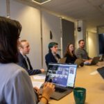 Quorum de Ross Video en una reunión híbrida corporativa con participantes presenciales y remotos en videollamada