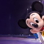 Mickey Mouse saluda al público en una función de BlackTrax en Disney on Ice sobre pista de hielo