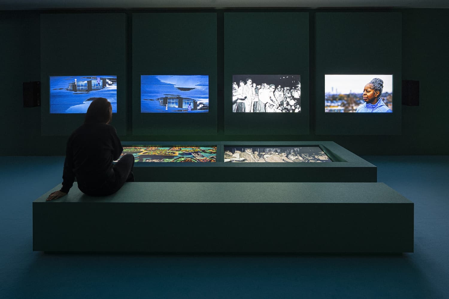Meyer Sound en exposición Thyssen-Bornemisza: instalación audiovisual con múltiples pantallas sincronizadas y visitante en sala