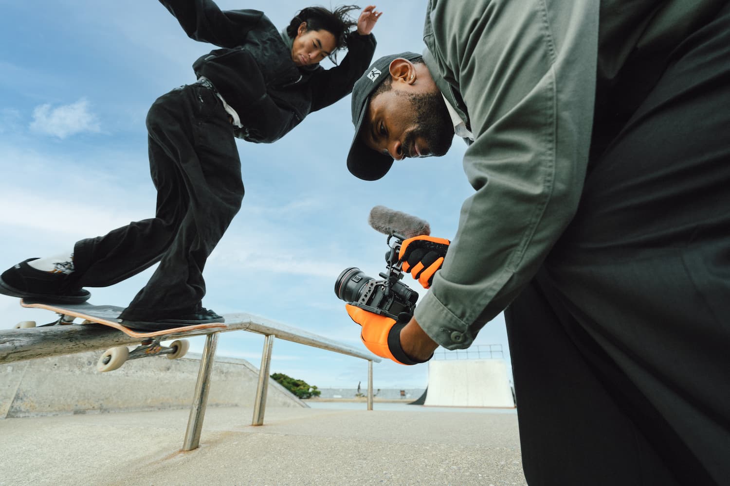 Videógrafo grabando en exterior con uno de los nuevos micrófonos de cañón para cámara de Audio-Technica