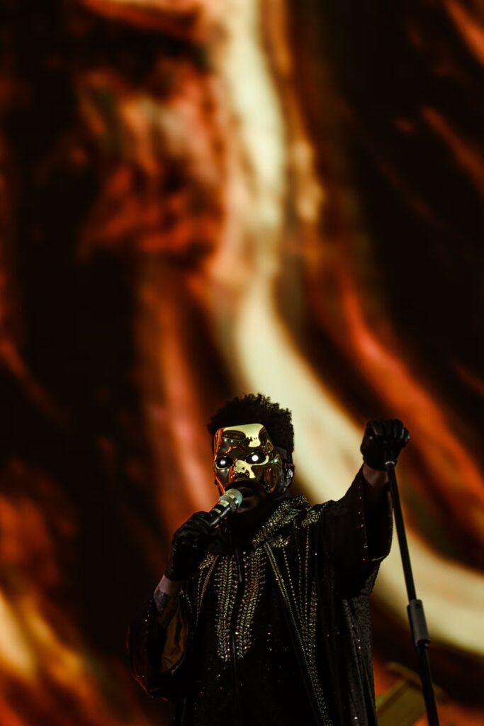 Sound Devices Astral en gira de estadios: artista en escenario con micrófono inalámbrico y puesta en escena con luces cálidas al fondo.