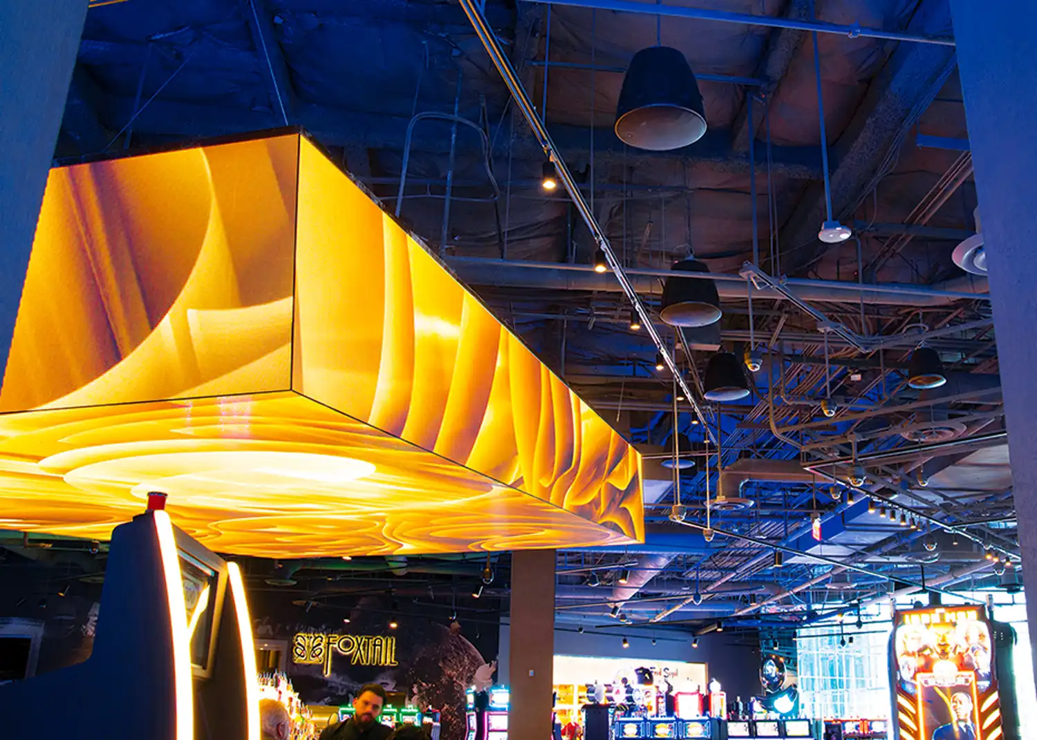 optimización acústica en techos descubiertos en espacio comercial con techo visto y altavoces colgantes