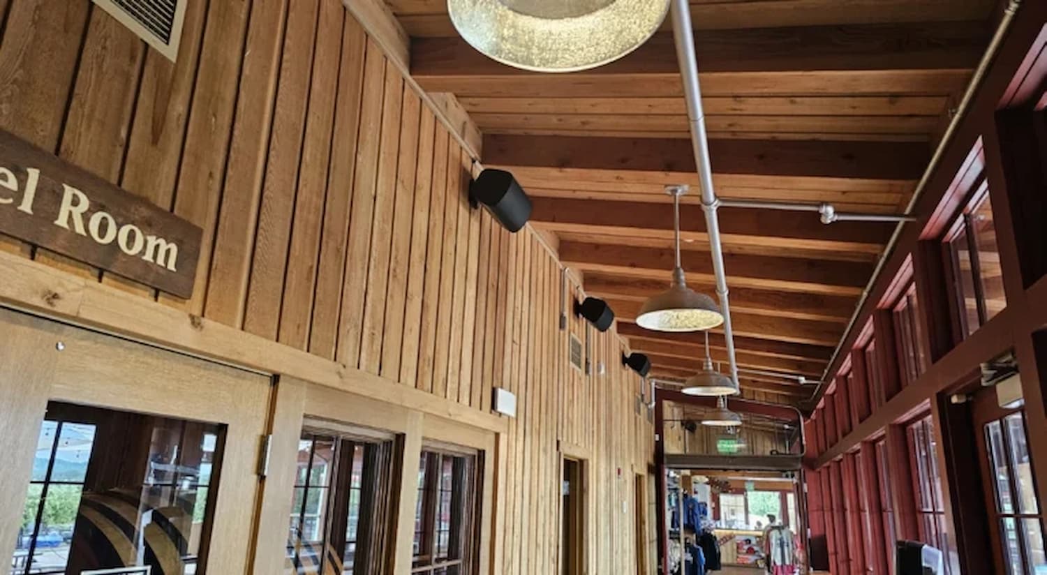 sistema de audio por zonas Biamp instalado en pasillo interior de Angry Orchard con altavoces en superficie integrados en paredes de madera