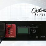 Sistema OPTIMAX3 para megafonía ferroviaria: unidad rack OPTIMUS OptimaX3 con matriz IP UMX-03 y panel de control, sobre fondo de estación