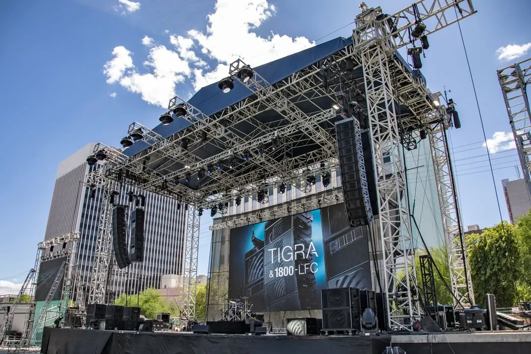 Escenario al aire libre con TIGRA en pantalla durante la presentación en Las Vegas