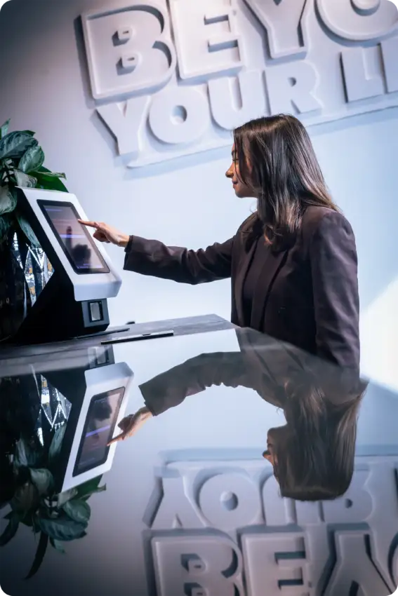 Registro digital de visitantes en oficina con pantalla táctil vinculada a sistema de reserva de salas de reuniones