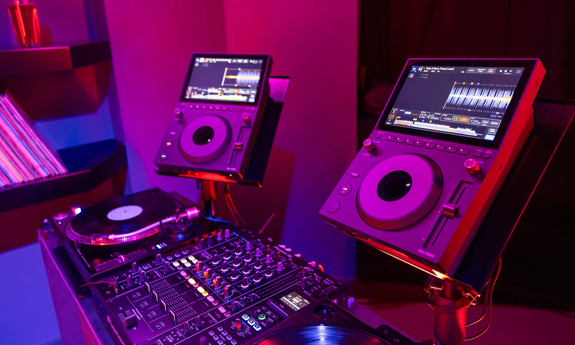 AlphaTheta presenta el CDJ-1500X, un reproductor DJ compacto con funciones profesionales y conectividad cloud 7 Dos reproductores AlphaTheta junto a un giradiscos en una cabina DJ compacta