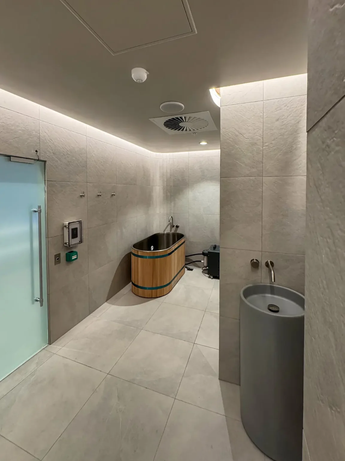 Sala de recuperación con bañera de agua fría y altavoz de techo Biamp de grado marino en el spa de Change North Adelaide