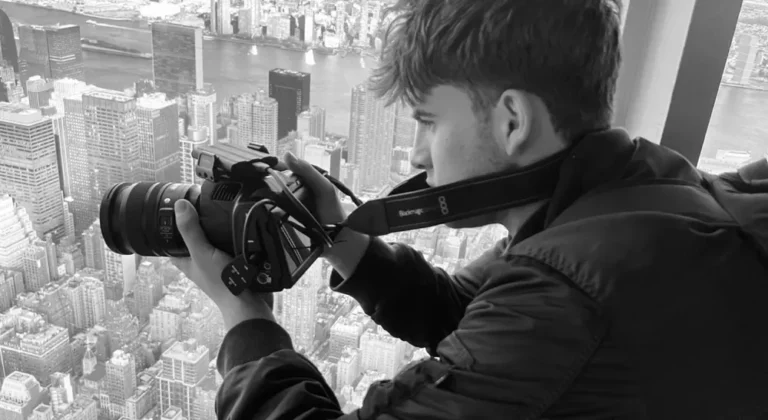 Estudiante graba con una Blackmagic Pocket Cinema Camera 6K Pro en educación audiovisual sobre el skyline de una ciudad