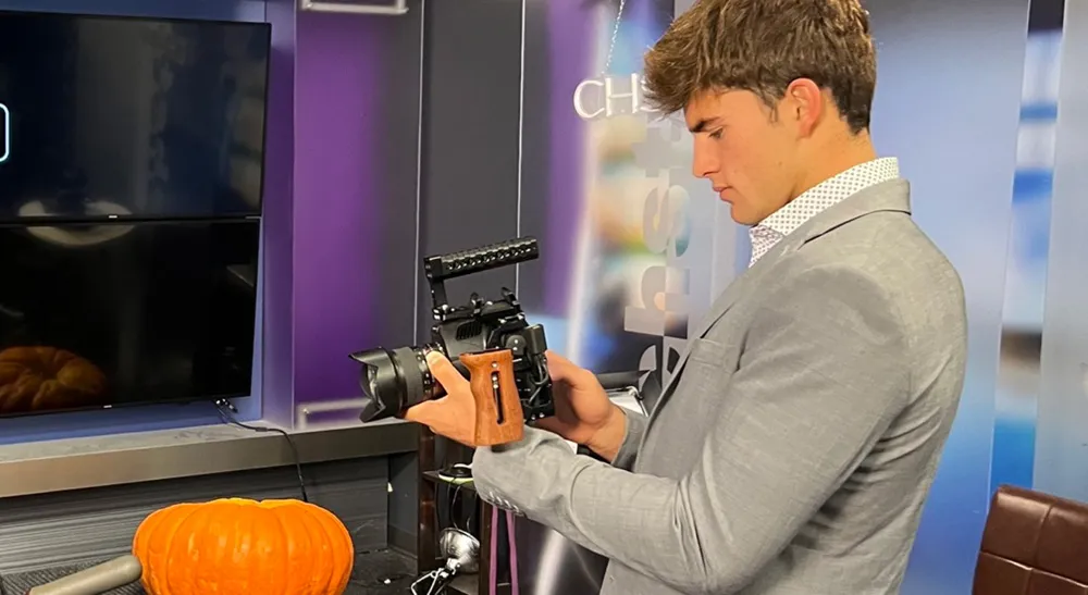 Joven presentador sostiene una Blackmagic Pocket Cinema Camera 6K Pro en un plató de televisión