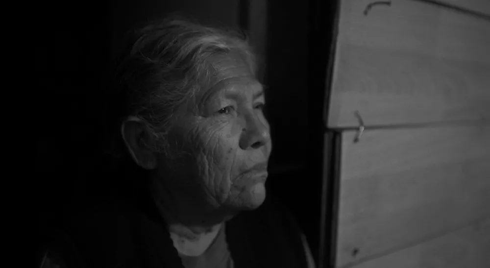 Blackmagic PYXIS 6K filma Lo invisible entre ríos y embarcaciones 3 Retrato en blanco y negro de una mujer junto a una ventana en el documental Lo invisible