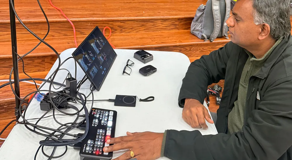 Producción multicámara con Blackmagic Design: un voluntario acciona el mezclador ATEM Mini Pro con la visualización simultánea de las cámaras.